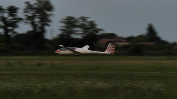 Planör, yelken uçağı, gün batımından sonra çimen havaalanına iniyor. — Stok video