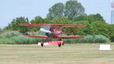 Tarihi kırmızı çift kanatlı uçak sarı alanlarla çevrili olarak havalanır.