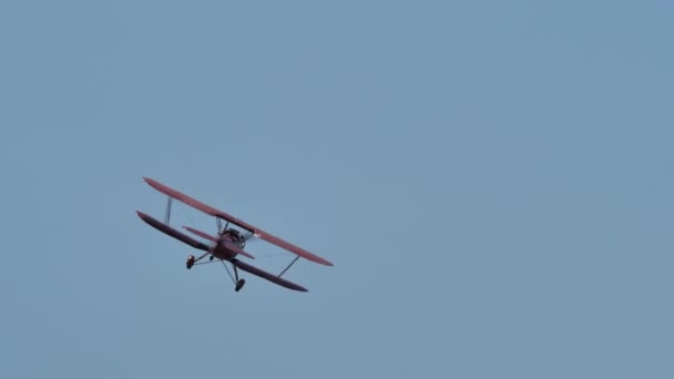 Biplan vole dans un ciel bleu sans nuages. Vidéo d'aviation 4K avec espace de copie. — Video