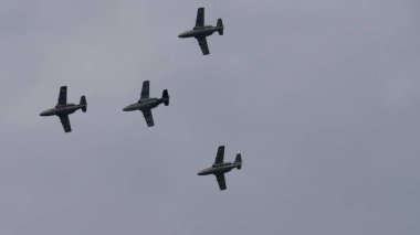 Bulutlu havada uçmakta olan dört askeri uçak. Boşluğu kopyala