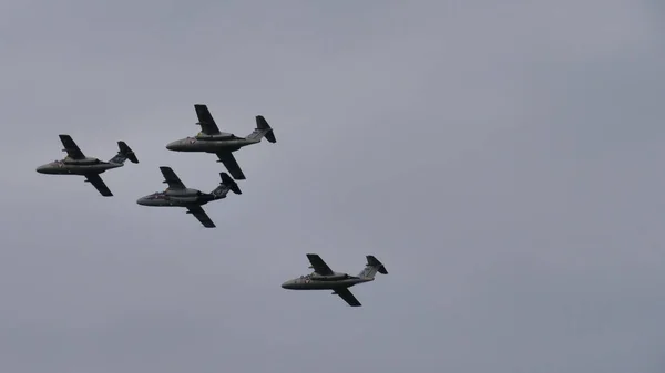 Quatre avions militaires en formation dans un ciel nuageux. Espace de copie — Photo
