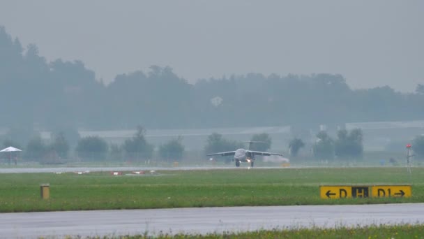 Militärjet landet auf sehr nasser Landebahn und wirft große Wasserspuren auf — Stockvideo