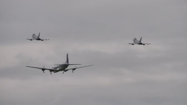 İki modern savaş uçağı eskortluk ettikleri retro pervane uçağından uzaklaşıyor. — Stok video