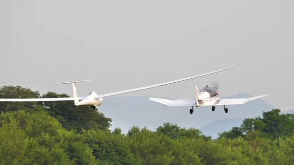 Propellerflugzeug schleppt ein Segelflugzeug im Flug lizenzfreie Stockfotos