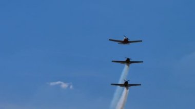 Ultralight uçakları mavi yaz gökyüzünde dumanla akrobatik manevralar yapar. 