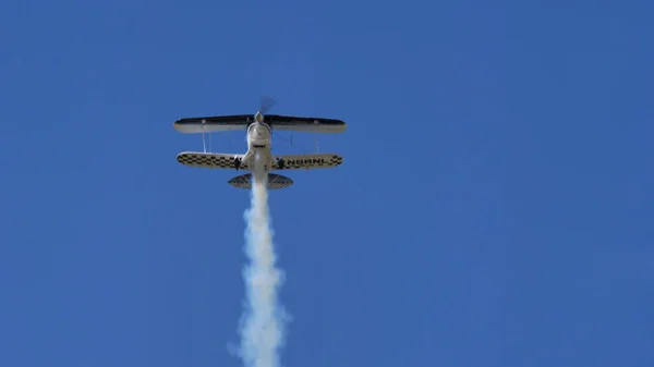 Vliegtuig in vlucht met rook doet een luchtprestatie — Stockfoto