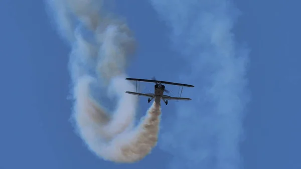 Avión Vintage vuela en el cielo azul con humo blanco — Foto de Stock