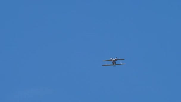 Aerobatic vintage tweedekker vliegtuig maakt een roll in de blauwe lucht zonder wolken — Stockvideo