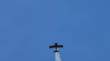 Mavi gökyüzünde akrobatik hareketler yapan klasik akrobatik çift kanatlı uçağın inanılmaz videosu.