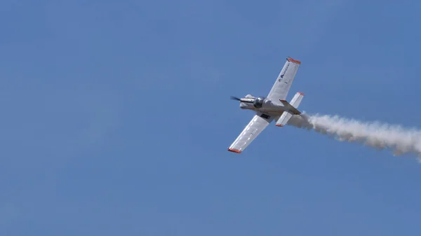 Дім будував легкий літак у польоті з білим димом. — стокове фото