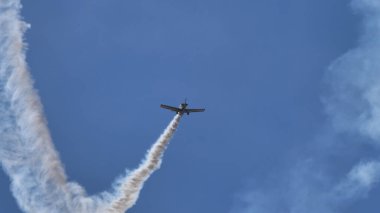 Mavi gökyüzünde uçmakta olan akrobatik uçak