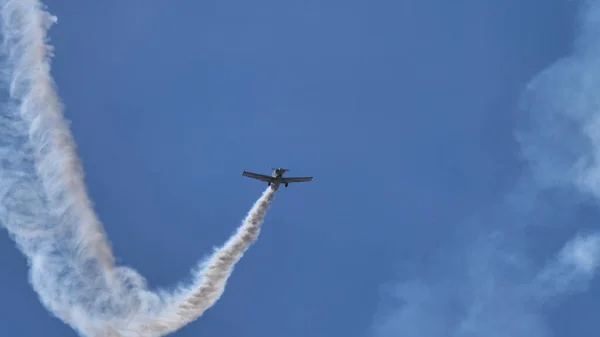 Μικρό αεροπλάνο υψώνεται κάθετα στον γαλάζιο ουρανό με λευκό ίχνος καπνού — Φωτογραφία Αρχείου