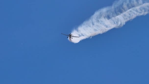 Flygplan med vita kemiska spår i blå himmel. Hög kvalitet 4k luftfart video — Stockvideo