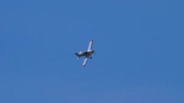 Güneşli bir günde mavi gökyüzü ile yüksek hızda uçan küçük bir uçak.