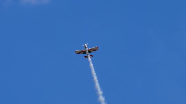 Home built historic aerobatic airplane does a series of rolls with white smoke — Stock Video