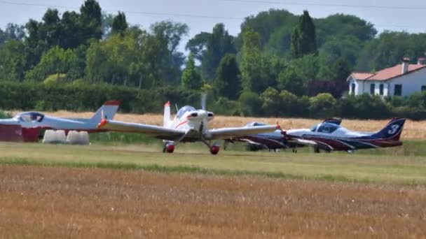 Lätt vintage flygplan landar på gräs landningsbana på en landsbygd flygplats — Stockvideo