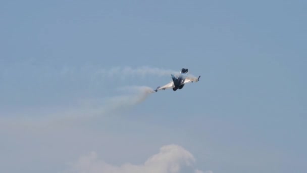Airplane does a series of rolls in flight in blue sky with white smokes — Stock Video