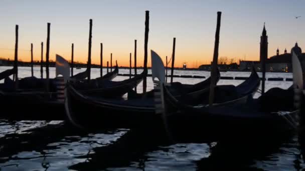 Silueta de góndolas en la laguna de Venecia con el amanecer al fondo — Vídeo de stock