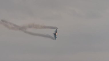 Savaş jeti yüksek performanslı bir dönüş yapıyor, art yakıcılar tam güçte.