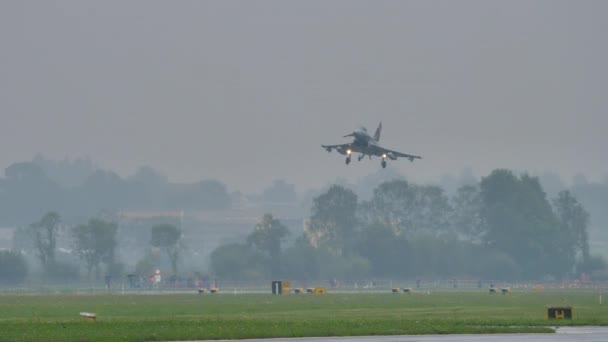 Avión de combate a reacción aterrizando con mal tiempo en una pista mojada — Vídeos de Stock