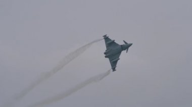 Delta kanatları üzerinde yoğunlaştırılmış buhar izleri olan askeri uçak uçuyor.