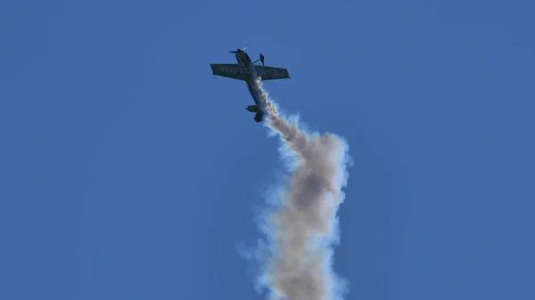 Plano acrobático parado en el aire verticalmente en el cielo azul con el humo blanco —  Fotos de Stock