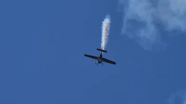 Aerobatic plane dives vertically in the blue sky. Copy space. — Stock Photo, Image