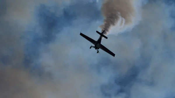 Μαύρη σιλουέτα αερόβιου αεροπλάνου καθώς κατεβαίνει κάθετα στον καπνό του — Φωτογραφία Αρχείου