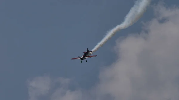 Samolot śmigła w locie na niebieskim niebie z białym szlakiem dymnym — Zdjęcie stockowe