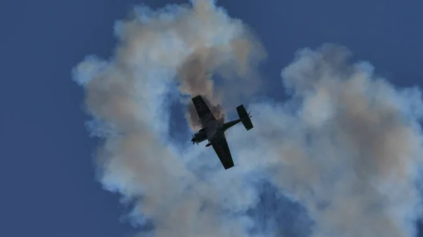 Zwart silhouet van een aerobatisch vliegtuig tijdens een extreme manoeuvre — Stockfoto