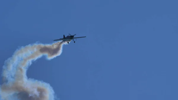 Petit avion hélice dans le ciel bleu avec de la fumée blanche. Espace de copie — Photo