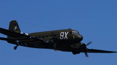 30 Mayıs 2025 Douglas C-47 Skytrain kokpiti ve burun bölümünü uçuş sırasında kapatıyor. 101. hava indirme tümeni amblemi taşıyan 2. Dünya Savaşı askeri nakliye uçakları. Boşluğu Kopyala