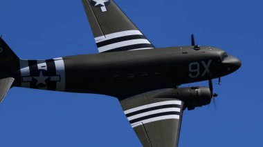 APPENZELL, SWitzERLAND - 30 Mayıs 2025: D-Day istila çizgileri uçmakta olan bir Douglas C-47 Skytrain askeri nakliye uçağında. Klasik Formasyon vintage savaş kuşu Hoher Kasten Airshow 'da gösteri yapıyor..
