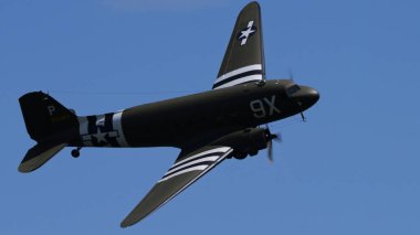 APPENZELL, SWitzERLAND - 31 Mayıs 2025 - 2. Dünya Savaşı Savaş Kuşu C-47 Skytrain taşımacılık uçağı bankacılığı kanat çizgileri gösteriyor, mavi gökyüzünü kopyala.