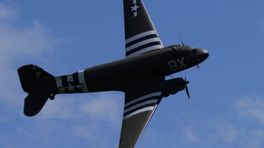 APPENZELL, SWitzERLAND - 31 Mayıs 2025 İstila çizgileri C-47 Skytrain askeri uçak gemisi dik banka silueti, uzay dramatik bulutlarını kopyala.