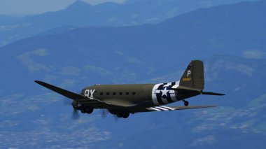 APPENZELL, SWitzERLAND - 31 Mayıs 2025: Douglas C-47 Skytrain Appenzell bölgesi üzerinde havalandı. 2. Dünya Savaşı anısına işgal çizgileri ve metin için negatif alanı olan uçaklar.