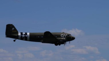 Douglas C-47 Skytrain 'in bulutlu bir ufuk çizgisinde yan profili 31 Mayıs 2025. 2. Dünya Savaşı hava taşıtı uçakları işgal çizgileri ve negatif alanı var..