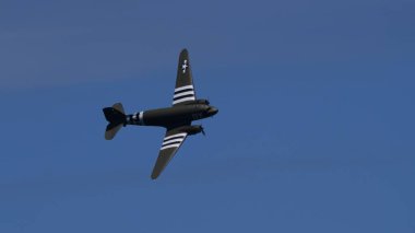 APPENZELL, SWitness ZERLAND - 31 Mayıs 2025: D-Day hatırası Douglas C-47 Skytrain uçuşta. İstila çizgileri ve temiz gökyüzü kopyalama alanı olan tarihi askeri uçak..