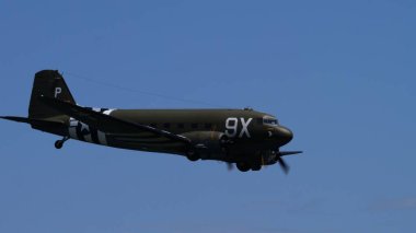 APPENZELL, SWitzERLAND - 31 Mayıs 2025: Douglas C-47 Skytrain anma uçakları mavi gökyüzü arka planına sahipler. Metin kopyalama alanı olan tarihi askeri nakliye uçağı.