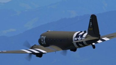 APPENZELL, SWitness ZERLAND - 31 Mayıs 2025 Operasyon Overlord temalı Douglas C-47 Skytrain askeri nakliye uçağı sol tarafa doğru hareket ediyor, gökyüzünü kopyalayın.