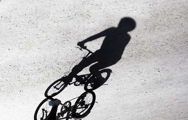 Schaduw van de fiets en de fietser op de weg — Stockfoto
