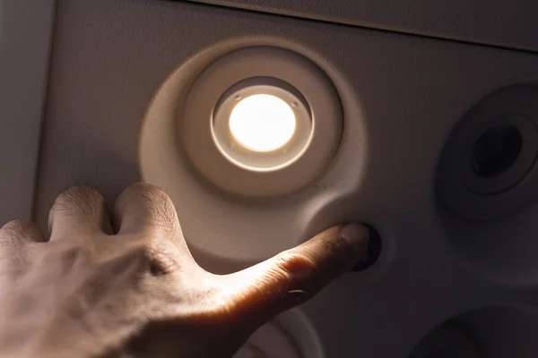 Passengers using the hand to turn off lights on the switch board — Stock Photo, Image