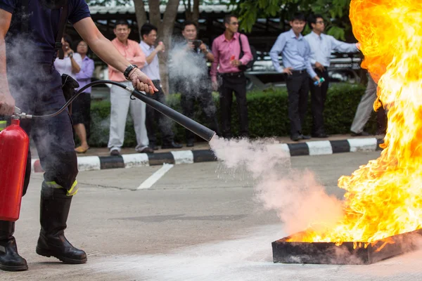 Instructeur tonen hoe u een brandblusser in een training Stockfoto