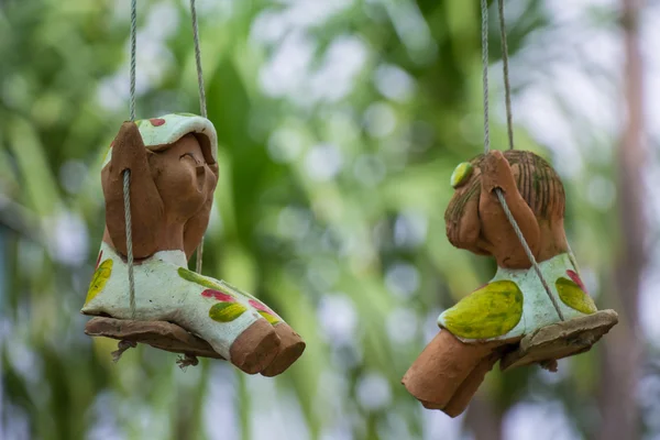 Happy clay doll on a swing — Stock Photo, Image