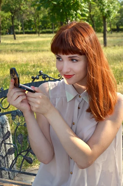 La ragazza guarda in un piccolo specchio — Foto Stock