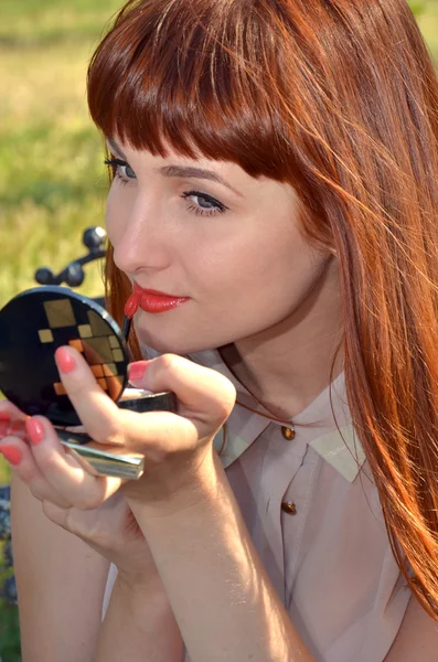 Red-haired girl paints lips — Stock Photo, Image