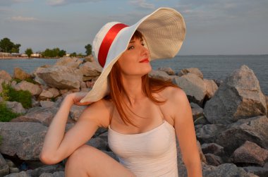 Kırmızı kurdele ile beyaz şapkalı kadın