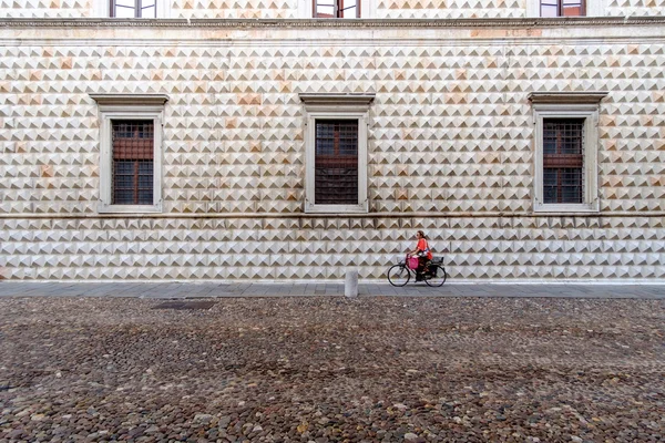 Mujer en bicicleta frente al famoso Palazzo dei Diamanti — Foto de Stock