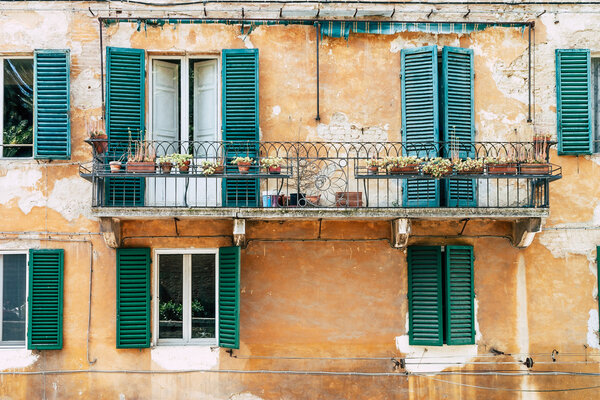 Facade of old building in Italy with balcony and windows