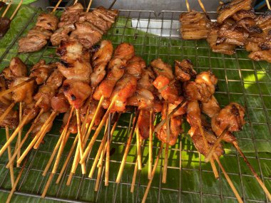 Markette satılık yeşil muz yaprağında ızgara tavuk şişleri.